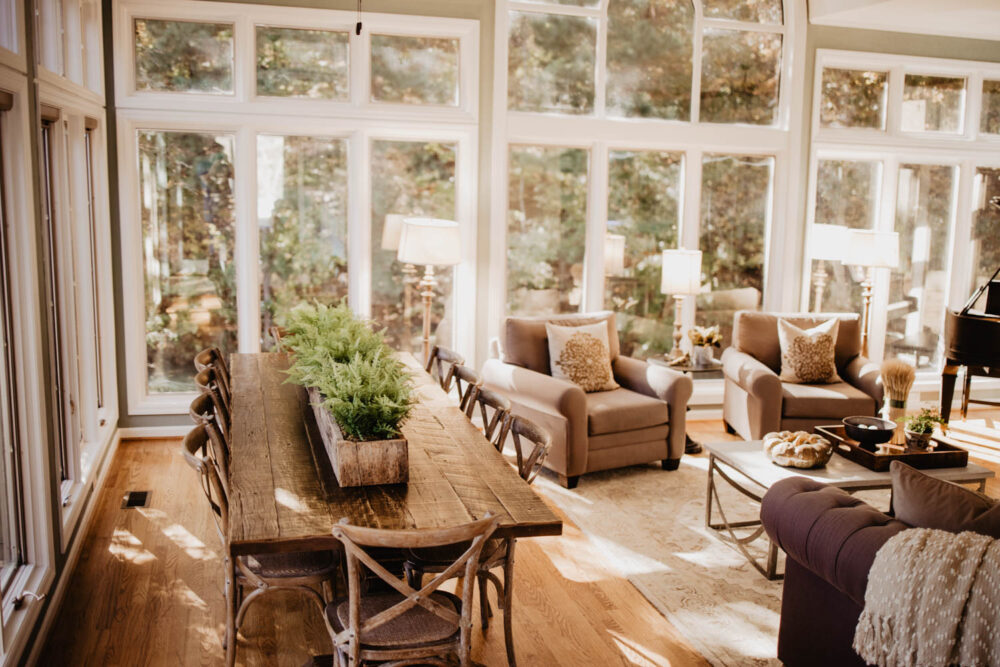 Spacious and brightly lit living and dining area of a WinShape Group Home, with large windows overlooking trees.