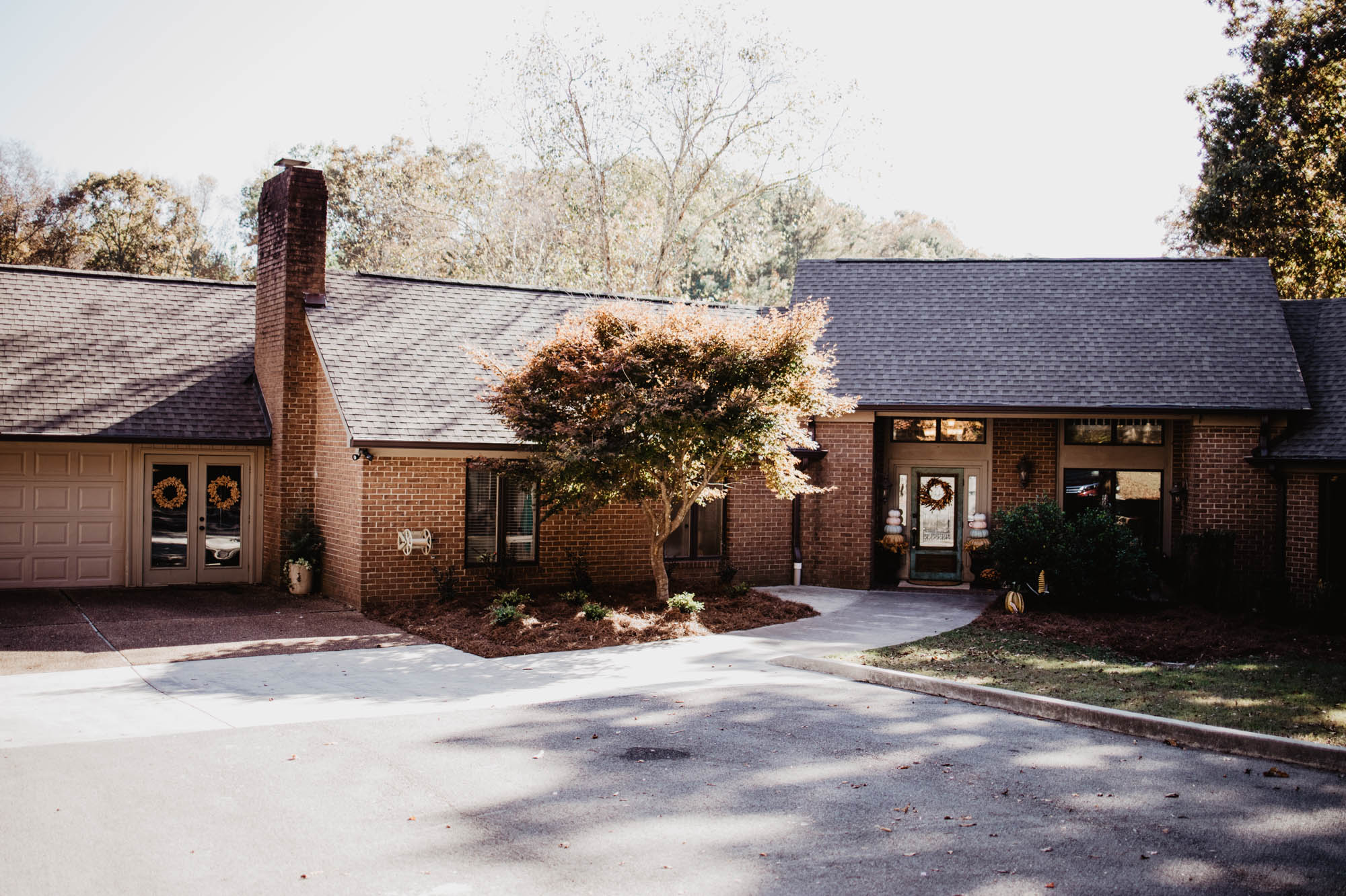 A brick foster home with a tree in the front of it.
