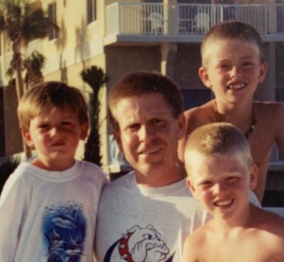 A man with a Georgia bulldogs shirt with his three sons