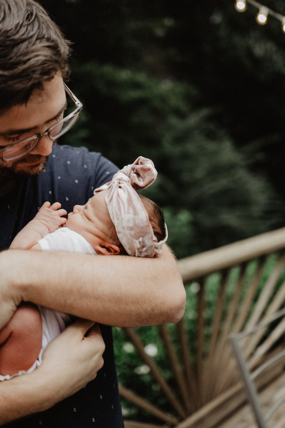 A man holding his daughter in his arms outside.