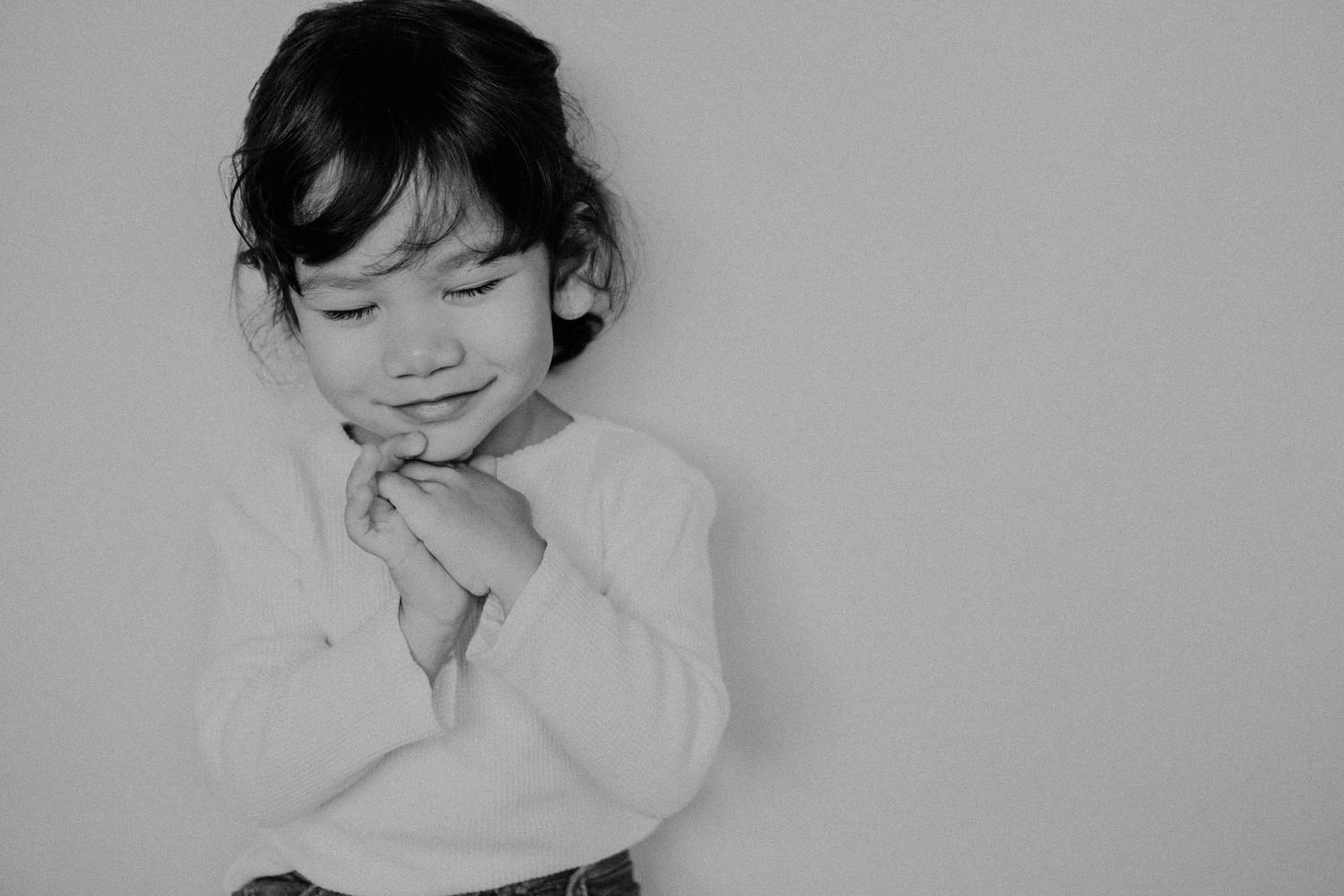 A girl showing biblical courage by holding her hands against her chin smiling
