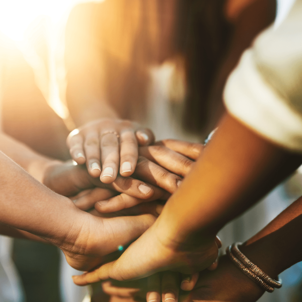 A close-up of multiple hands on top of each other.