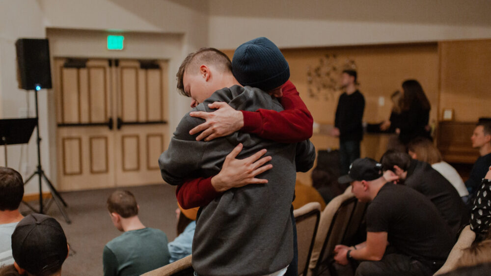 Two boys hugging each other in a church.