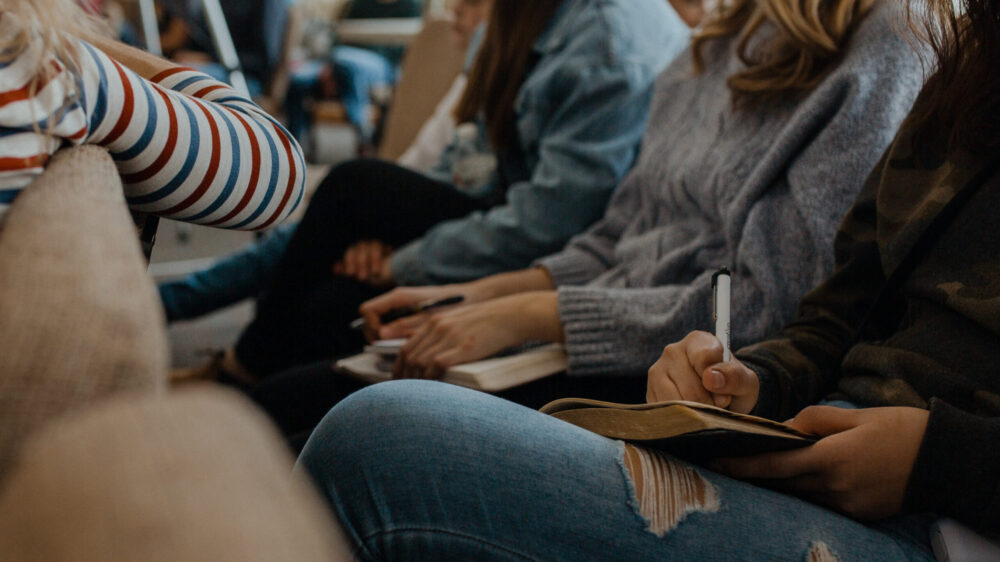 A group of women writing in their bibles.