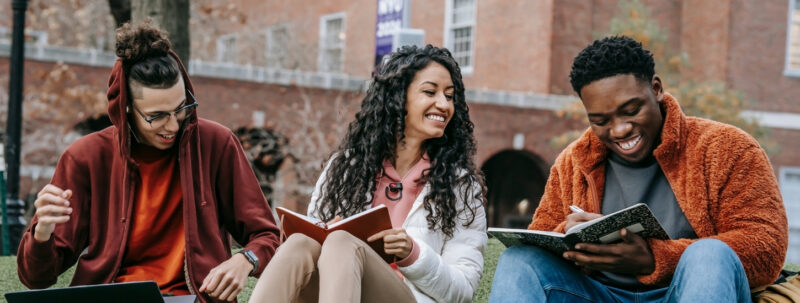 Three students laughing while studying at school
