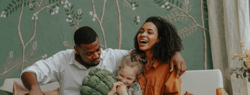 Foster parents smiling with a foster child